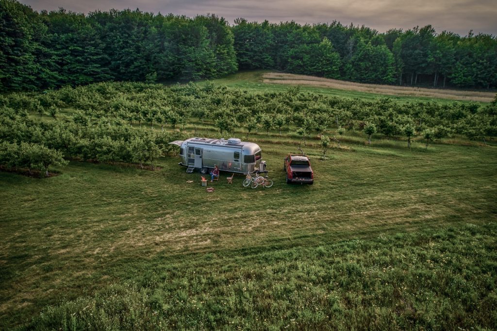 a family hanging out near an airstream RV